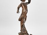 une table en bronze ancien sur laquelle est représentée une femme tenant un oiseau sur la tête