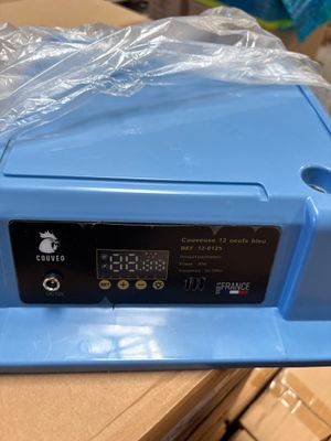 une boîte en plastique bleue sur laquelle figure une horloge numérique