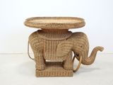 a wicker elephant table with a tray on top of it