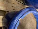 two blue vases sitting on a pallet next to each other