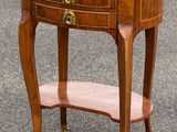 une petite table en bois avec un plateau en marbre, montée sur roulettes