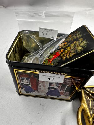 une petite boîte en fer-blanc avec une cuillère et un repose-cuillère posés sur une table