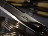 a close up of a knife and other kitchen utensils on a table
