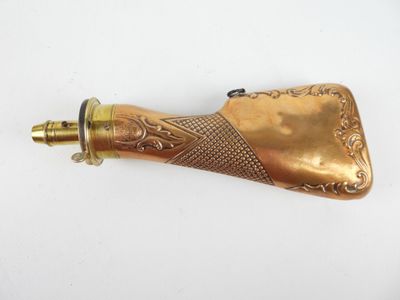 une vieille pipe en laiton avec une poignée en laiton posée sur une surface blanche