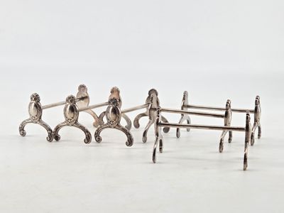 three silver figurines of people sitting on a bench
