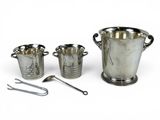 trois tasses en argent et une cuillère posées les unes à côté des autres