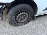 a white car with a flat tire on the street