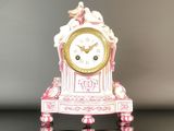 une horloge rose et blanche posée sur une table