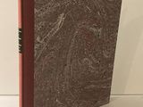 un livre à la couverture rouge posé sur une table blanche