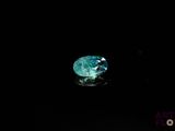 a close up of a green diamond on a black surface