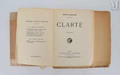 un livre ouvert posé sur une table à côté d'un mur blanc