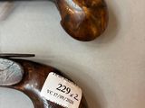 pair of old guns with labels on them sitting on a table