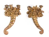 trois crochets métalliques dorés ornés de fleurs, posés sur une surface blanche