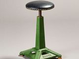 an image of a green stool with a black leather seat