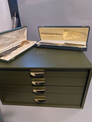 une boîte verte surmontée de deux tiroirs
