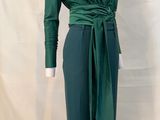the woman is wearing a green top and green pants