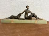 statue of a woman and a dog sitting on a marble base