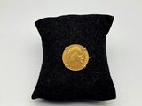 a gold coin sitting on top of a black pillow