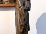 a statue of a man holding a book on a table