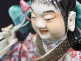 a figurine of a woman with a bird on her head
