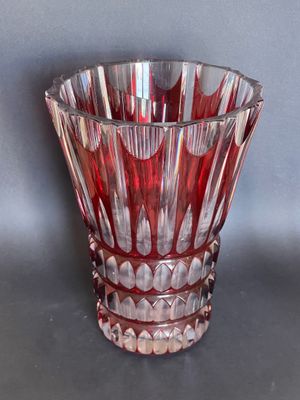a red glass vase that is sitting on a table