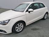 a picture of a white car parked in front of a building