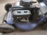 a blue lawn mower sitting on a wooden floor