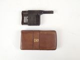 un gros plan d'un pistolet et d'un portefeuille posés sur une surface blanche