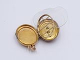 a small gold locke with a glass lid on a white surface