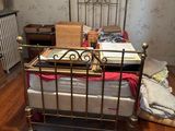 a bed that is in a room with a lot of stuff on the floor