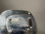 a silver plate with a handle on it on a table