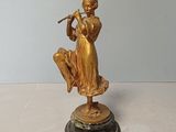 une statue en or représentant une femme jouant de la flûte