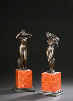 paire de figurines en bronze représentant une femme et un homme, posées sur des socles en marbre