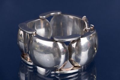 gros plan d'un bracelet en argent sur une surface noire