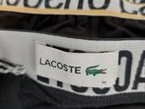 the label on the back of a black jacket with a crocodile on it