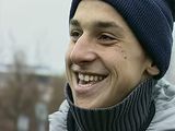 a young man wearing a blue hat and scarf