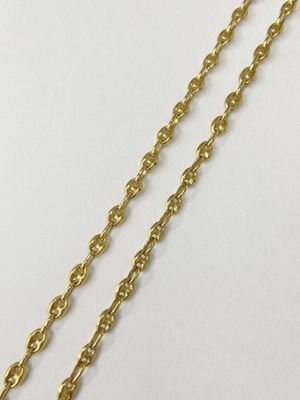 a close up of a gold chain on a white surface