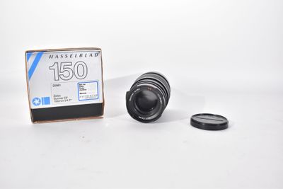the camera lens is sitting next to the box of the camera
