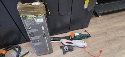 de nombreux outils qui traînent par terre à côté d'un réfrigérateur
