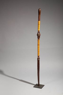 an old wooden stick with a wooden handle on a metal stand