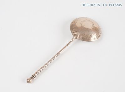 a silver spoon with a handle on a white surface