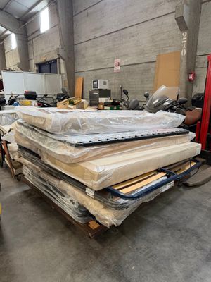 un gros tas de matelas et d'autres objets dans un entrepôt