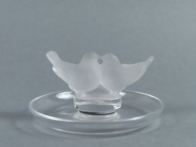 un bougeoir en verre orné d'une fleur en verre