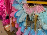 de nombreuses plumes de différentes couleurs suspendues à un présentoir dans un magasin
