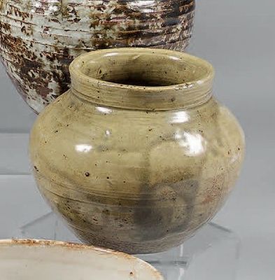 trois vases posés sur une table en verre, avec une assiette blanche