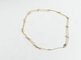 un collier en or orné d'une pierre noire sur un fond blanc
