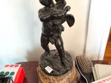 une statue représentant un garçon tenant un bébé dans ses bras, posée sur une table