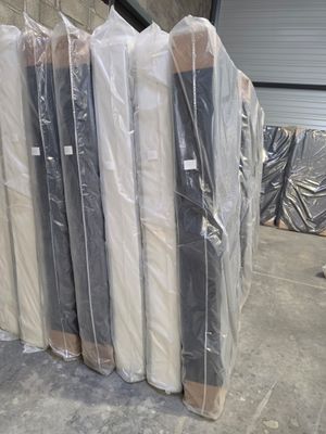 many mattresses wrapped up in plastic bags in a warehouse