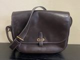 un sac à main en cuir marron posé sur une table en bois