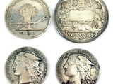 quatre types différents de pièces d'argent sur une surface blanche